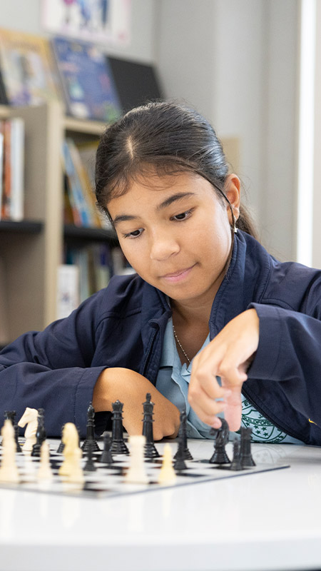 St Pat's Guildford student playing chess in the school library