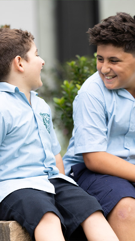 Happy students at St Patrick's Primary Guildford. The students are sitting outdoors.