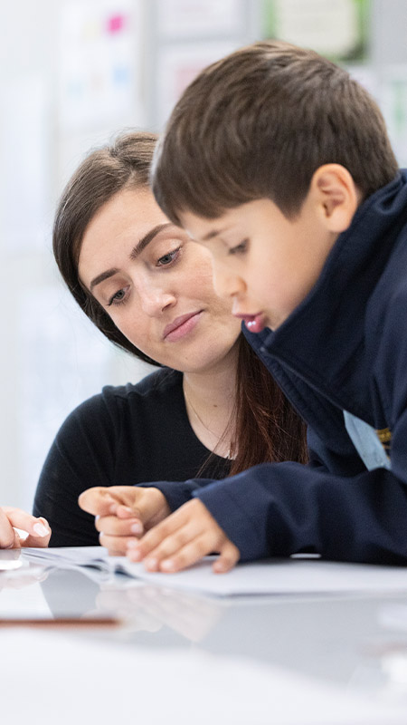 Teacher assisting a St Pat's Guildford student
