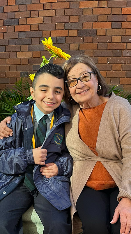 St Patrick's Primary Guildford student posing with grandmother in front of the sunflowers in the school garden.
