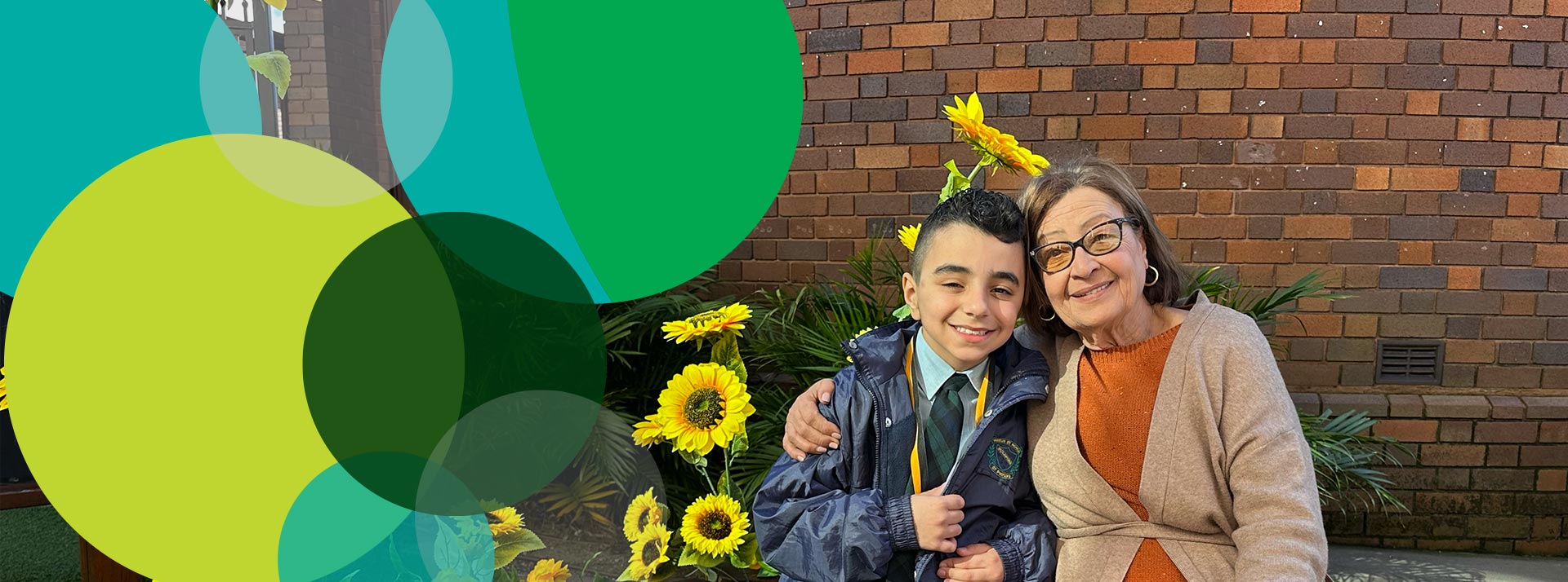 St Patrick's Primary Guildford student posing with grandmother in front of the sunflowers in the school garden.