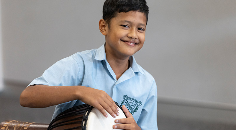 Student playing bongo drums at St Patrick's Primary Guildford