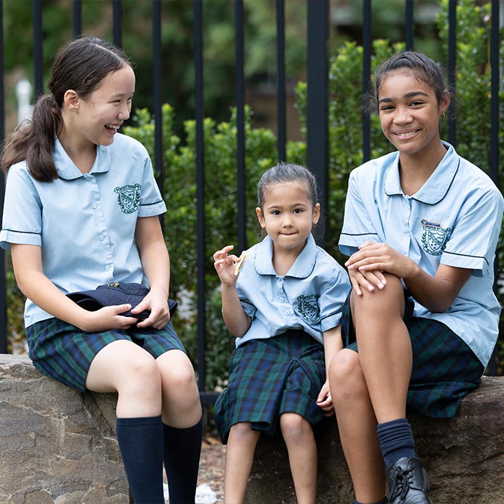 St Patrick's Primary Guildford students sitting outside. Year six buddies are with their kindergarten buddy.